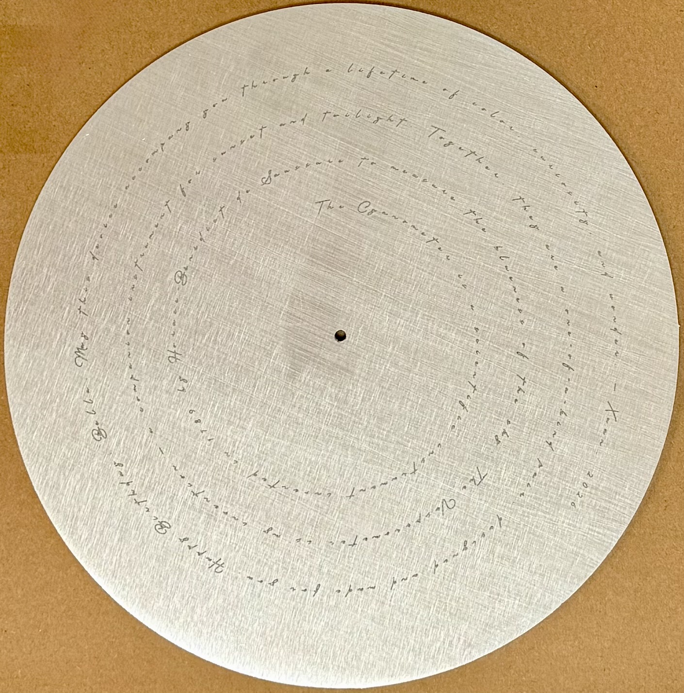 Handwritten dedication engraved in spirals on aluminum