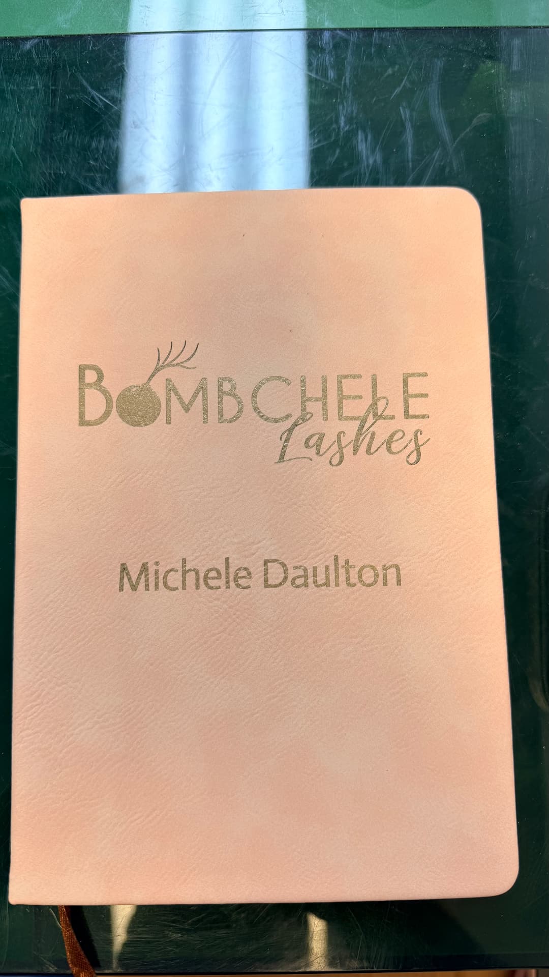 Laser engraved logo and name on a blush leather journal